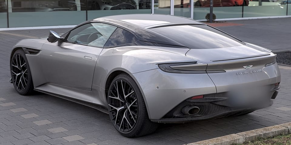 Aston Martin DB12 from the rear right, showing the tail lights and exhaust