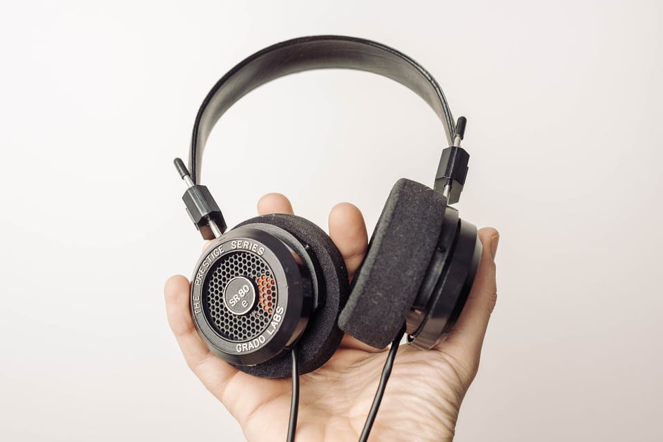 Grado SR80e open-back headphones held up against a white background