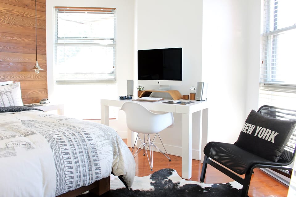 Bedroom with a timber feature wall and a desk by the window